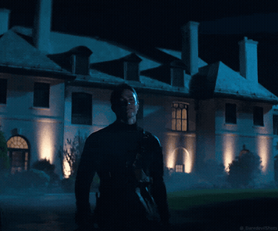 A Man Stands In Front Of A Large White Building At Night With The Words Daredevilshots Below Him GIF