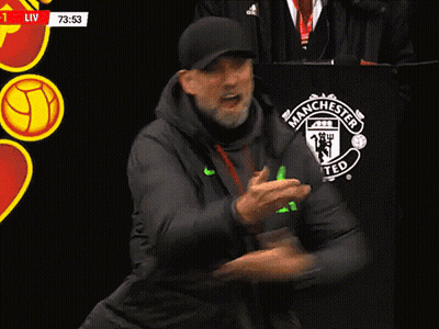 A Man Stands In Front Of A Manchester United Logo GIF