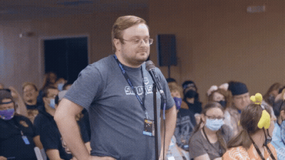 A Man Stands In Front Of A Microphone Wearing A Shirt That Says Sdue GIF