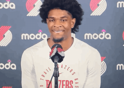 A Man Stands In Front Of A Microphone Wearing A Trailblazers Shirt GIF