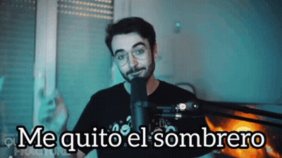 A Man Stands In Front Of A Microphone With The Words Me Quito El Sombrero Below Him GIF