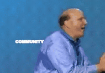 A Man Stands In Front Of A Microsoft Community Windows Sign GIF