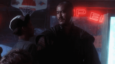 A Man Stands In Front Of A Neon Sign That Says Pepsi GIF