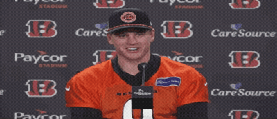 A Man Stands In Front Of A Paycor Sign GIF