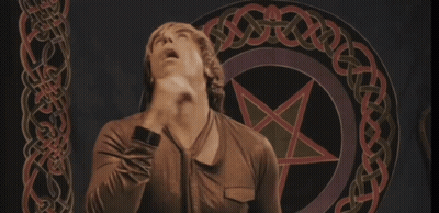 A Man Stands In Front Of A Pentagram With A Celtic Knot Around It GIF