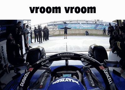 A Man Stands In Front Of A Race Car With The Words Vroom Vroom Written Above Him GIF