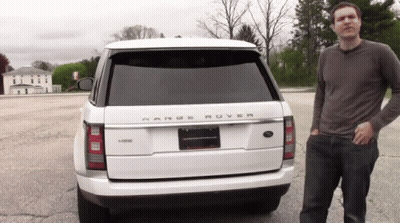 A Man Stands In Front Of A Range Rover GIF