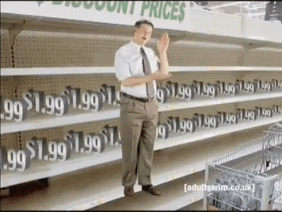 A Man Stands In Front Of A Row Of Empty Shelves That Say 1.99 GIF