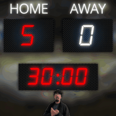 A Man Stands In Front Of A Scoreboard That Reads Home 5-0 Away 0 GIF