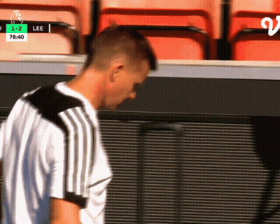 A Man Stands In Front Of A Scoreboard That Says Lee 1-2 GIF