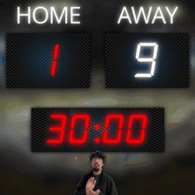 A Man Stands In Front Of A Scoreboard Which Says Home And Away GIF