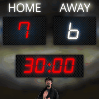 A Man Stands In Front Of A Scoreboard With Home And Away Written On It GIF
