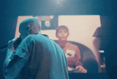 A Man Stands In Front Of A Screen That Says ' A ' On It GIF