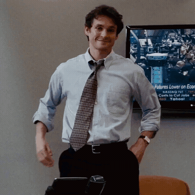 A Man Stands In Front Of A Screen That Says Futures Lower On Economic News GIF