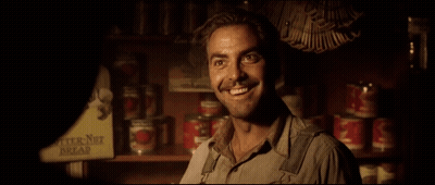 A Man Stands In Front Of A Shelf With Butter Nut Bread Cans On It GIF