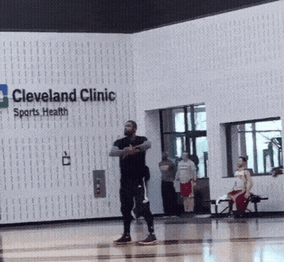 A Man Stands In Front Of A Sign For Cleveland Clinic Sports Health GIF