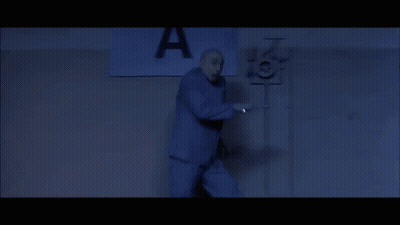 A Man Stands In Front Of A Sign That Says A GIF