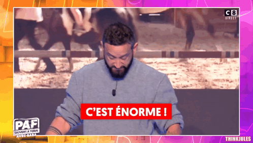 A Man Stands In Front Of A Sign That Says C Est Enorme GIF