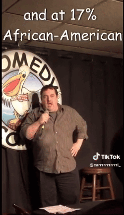 Man Standing In Front Of Comedy Club Sign GIF