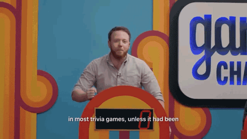 A Man Stands In Front Of A Sign That Says " In Most Trivia Games " GIF