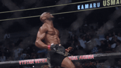 A Man Stands In Front Of A Sign That Says Kamaru Usma On It GIF
