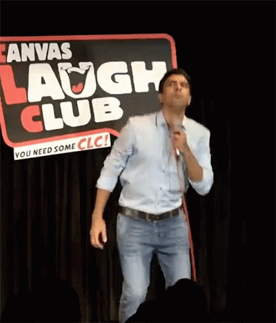 A Man Stands In Front Of A Sign That Says Laugh Club GIF