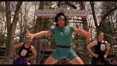 A Man Stands In Front Of A Sign That Says Perkis Power GIF