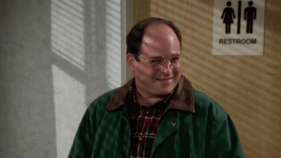 A Man Stands In Front Of A Sign That Says Restroom GIF