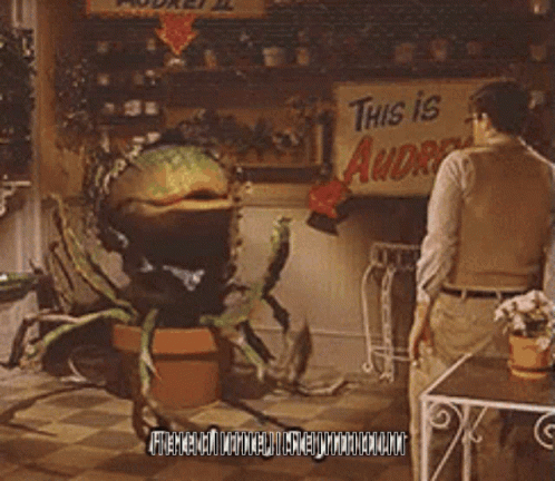 A Man Stands In Front Of A Sign That Says " This Is Audrey " GIF
