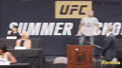 A Man Stands In Front Of A Sign That Says Ufc On It GIF