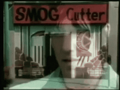 A Man Stands In Front Of A Smog Cutter Shop GIF