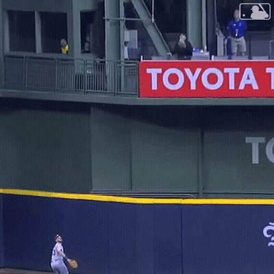 A Man Stands In Front Of A Toyota Ad GIF