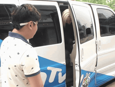 A Man Stands In Front Of A Van That Says ' Tv ' On The Side GIF