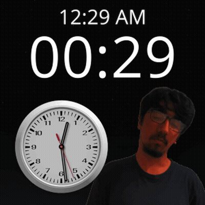 A Man Stands In Front Of A Wall Clock That Says 12:29 Am GIF