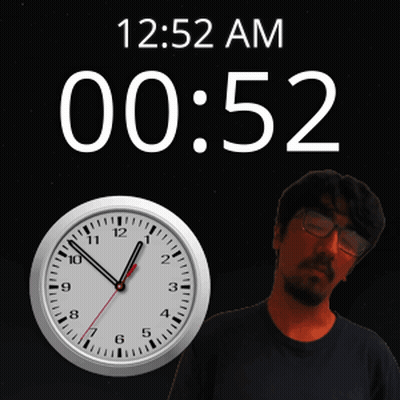 A Man Stands In Front Of A Wall Clock That Says 12:52 Am GIF