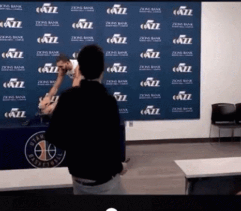 A Man Stands In Front Of A Wall That Has Jazz Written On It GIF