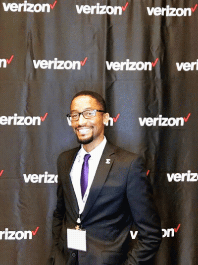 A Man Stands In Front Of A Wall That Says Verizon GIF