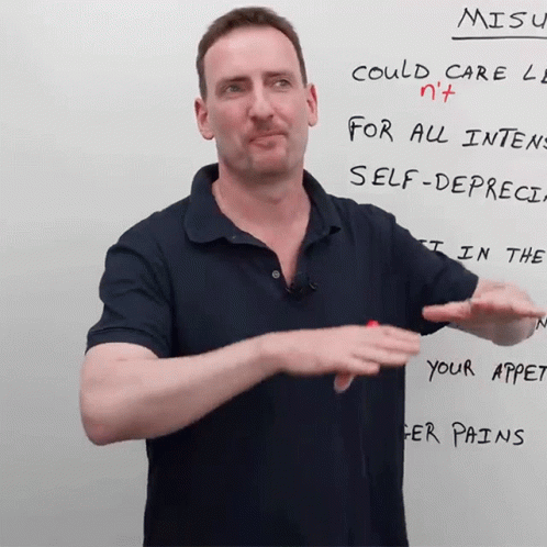 A Man Stands In Front Of A White Board That Says Misu On It GIF