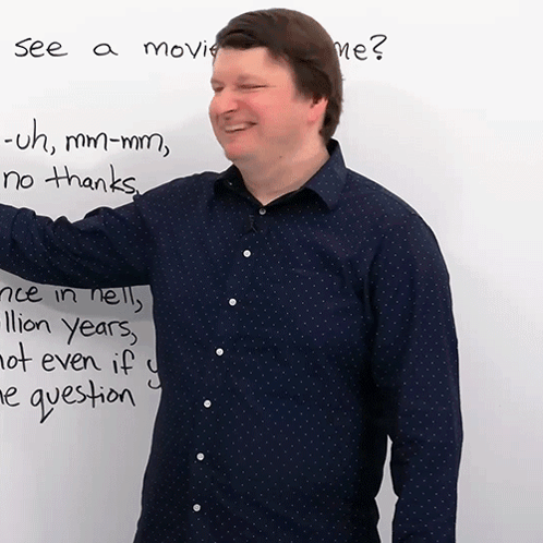 A Man Stands In Front Of A White Board That Says " See A Movie Me " On It GIF