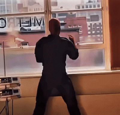 A Man Stands In Front Of A Window With A Sign That Says " Open " GIF