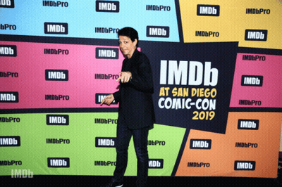 A Man Stands In Front Of An Imdb At San Diego Comic Con 2019 Banner GIF