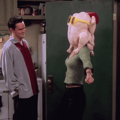 A Man Stands Next To A Woman Wearing A Turkey Head And Sunglasses GIF