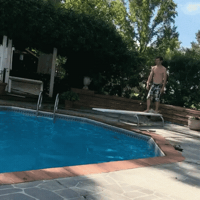 A Man Stands On A Diving Board Near A Pool GIF