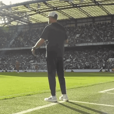 A Man Stands On A Soccer Field In Front Of A Sign That Says Chelsea And Religion GIF