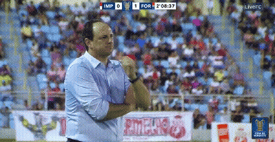 A Man Stands On A Soccer Field In Front Of A Sign That Says ' Rionegro ' GIF