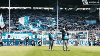 A Man Stands On A Soccer Field In Front Of A Sign That Says Vil1848.tv GIF