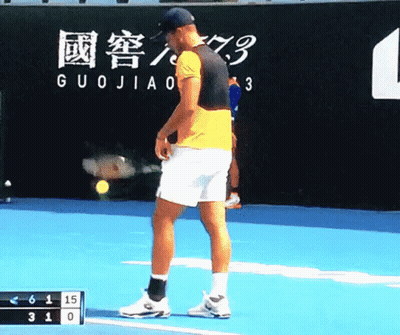 A Man Stands On A Tennis Court In Front Of A Wall That Says Guojiao On It GIF