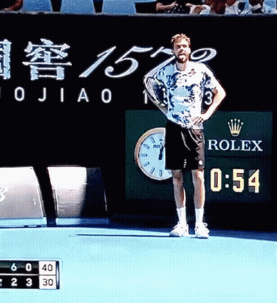 A Man Stands On A Tennis Court With A Rolex Sign Behind Him GIF
