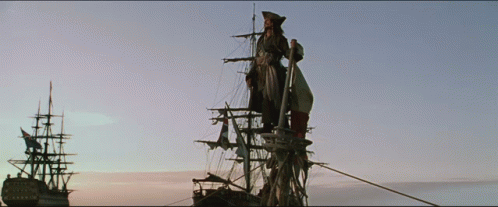 A Man Stands On The Mast Of A Ship In The Middle Of The Ocean GIF