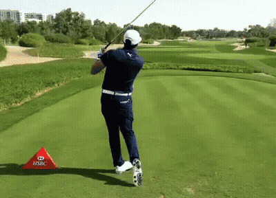 A Man Swinging A Golf Club On A Golf Course With A Hsbc Sign In Front Of Him GIF
